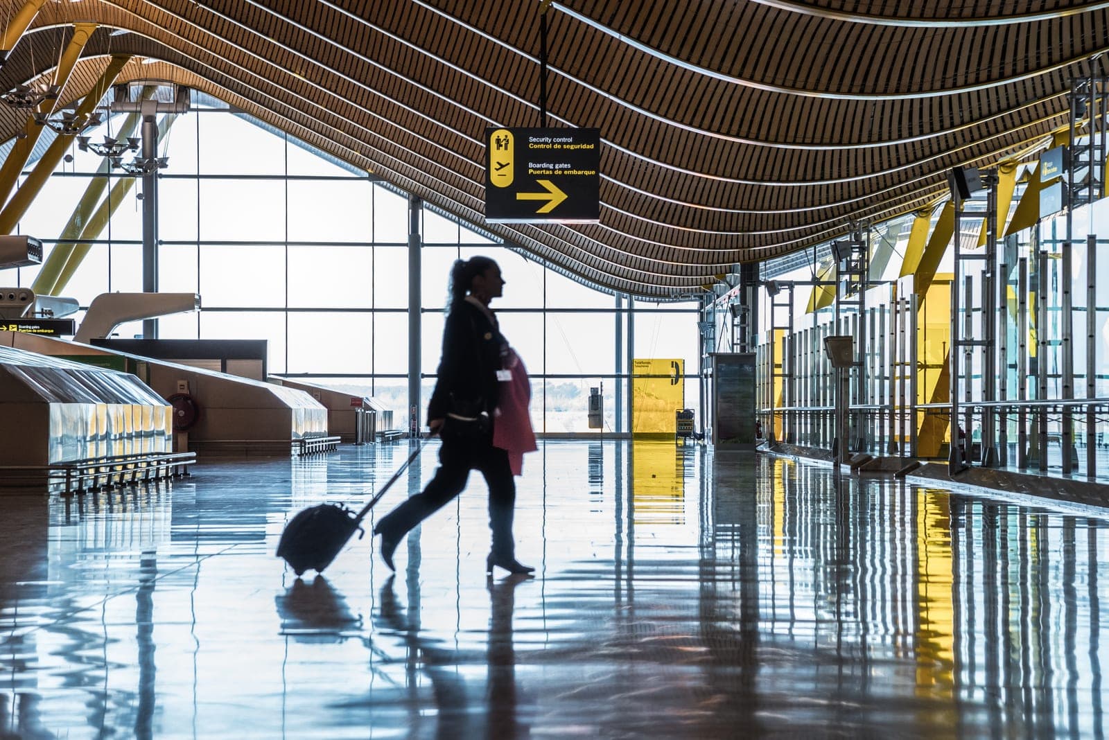 Voyageurs avec leurs valises dans un terminal d'aéroport ensoleillé