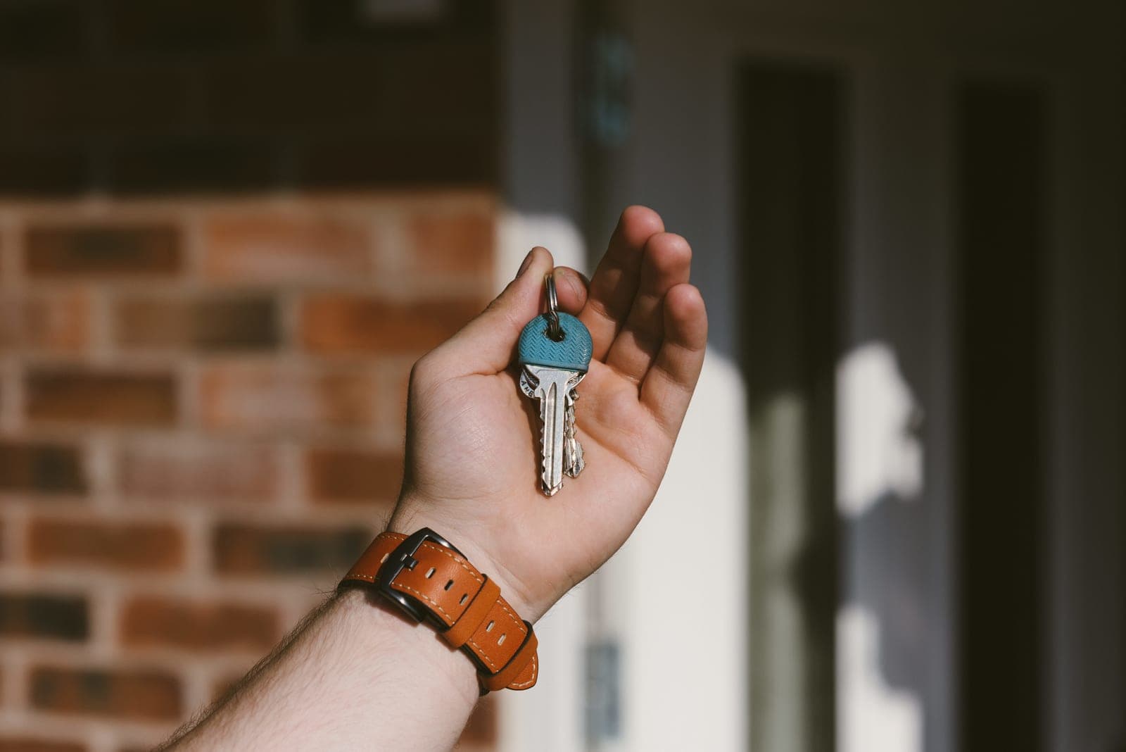 Une main tend les clés d'un logement